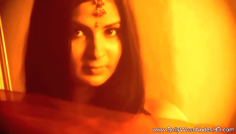 Indian brunette is dancing on a couch in her bedroom